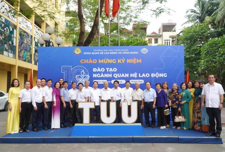 A group of people standing in front of a sign

Description automatically generated