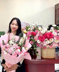 A person holding flowers in front of a table

Description automatically generated